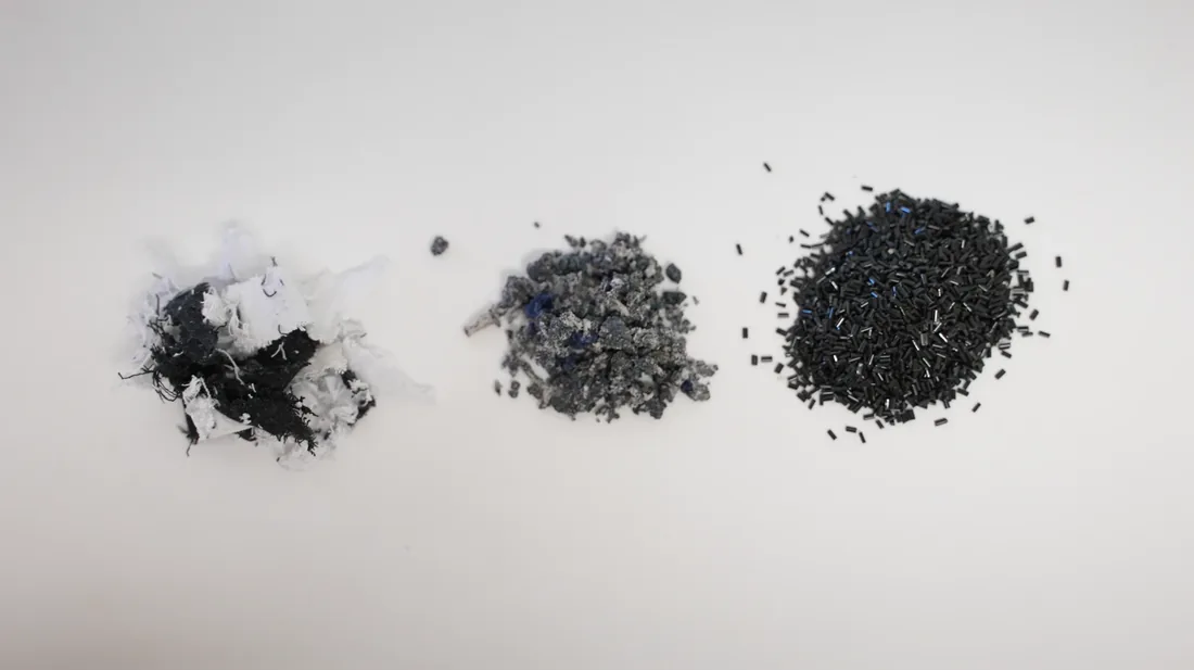 End-of-life textiles beside recovered material and black recycled polyester pellets